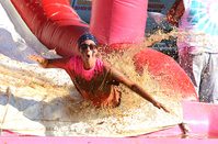 Muddy Mamas participants climb a muddy obstacle during the Girls Inc. fundraiser at the Washington County Agricultural Education Center.