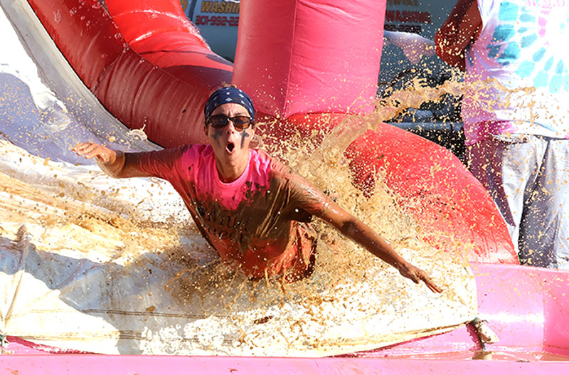 Muddy Mamas participants climb a muddy obstacle during the Girls Inc. fundraiser at the Washington County Agricultural Education Center.